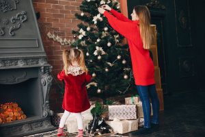 mother and daughter decorating christmas tree